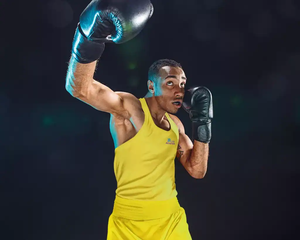 Boxing athlete wearing gloves and yellow sportswear, preparing for a match or training session.