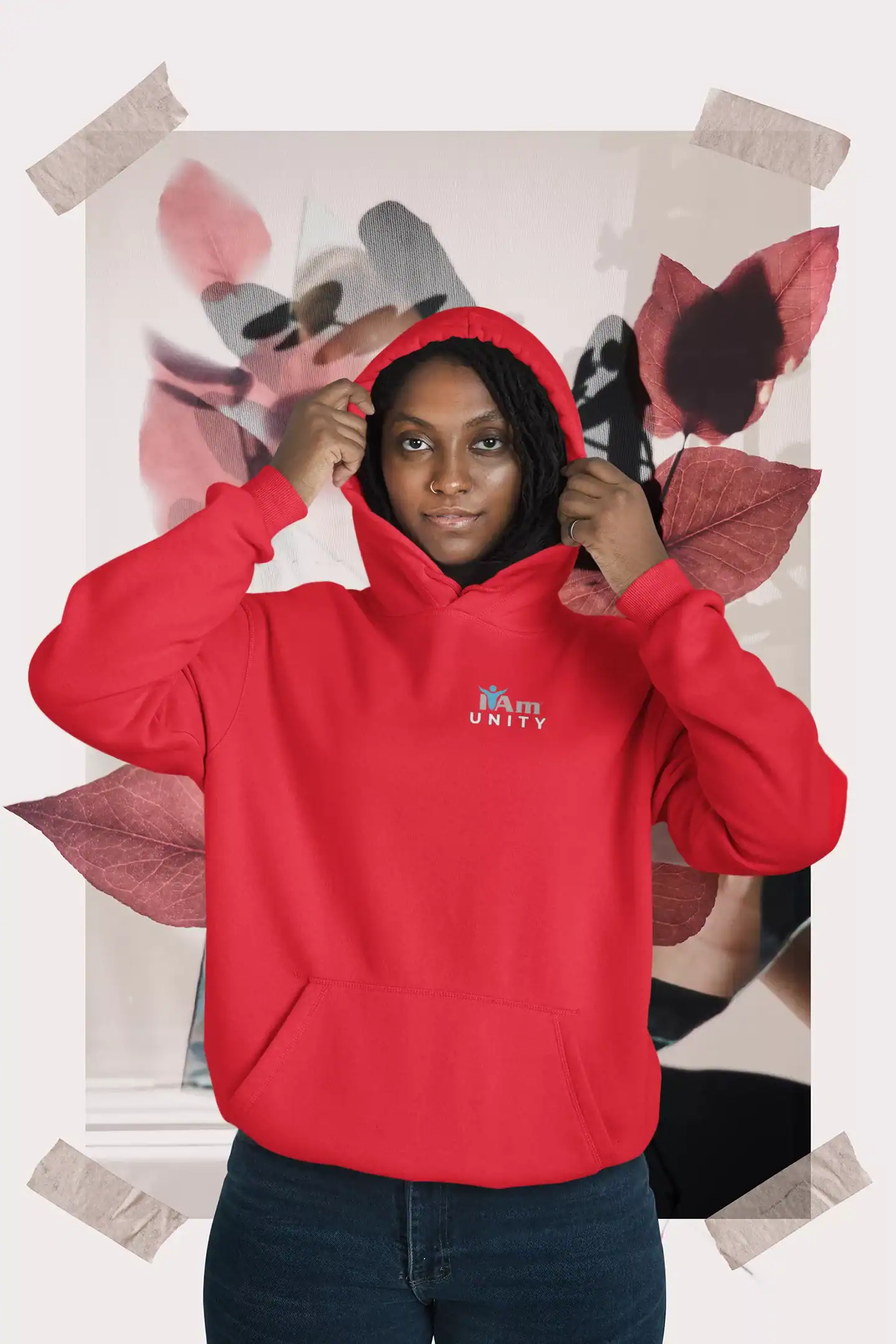 Woman wearing red hoodie with 'I Am Unity' logo, standing in front of artistic backdrop.