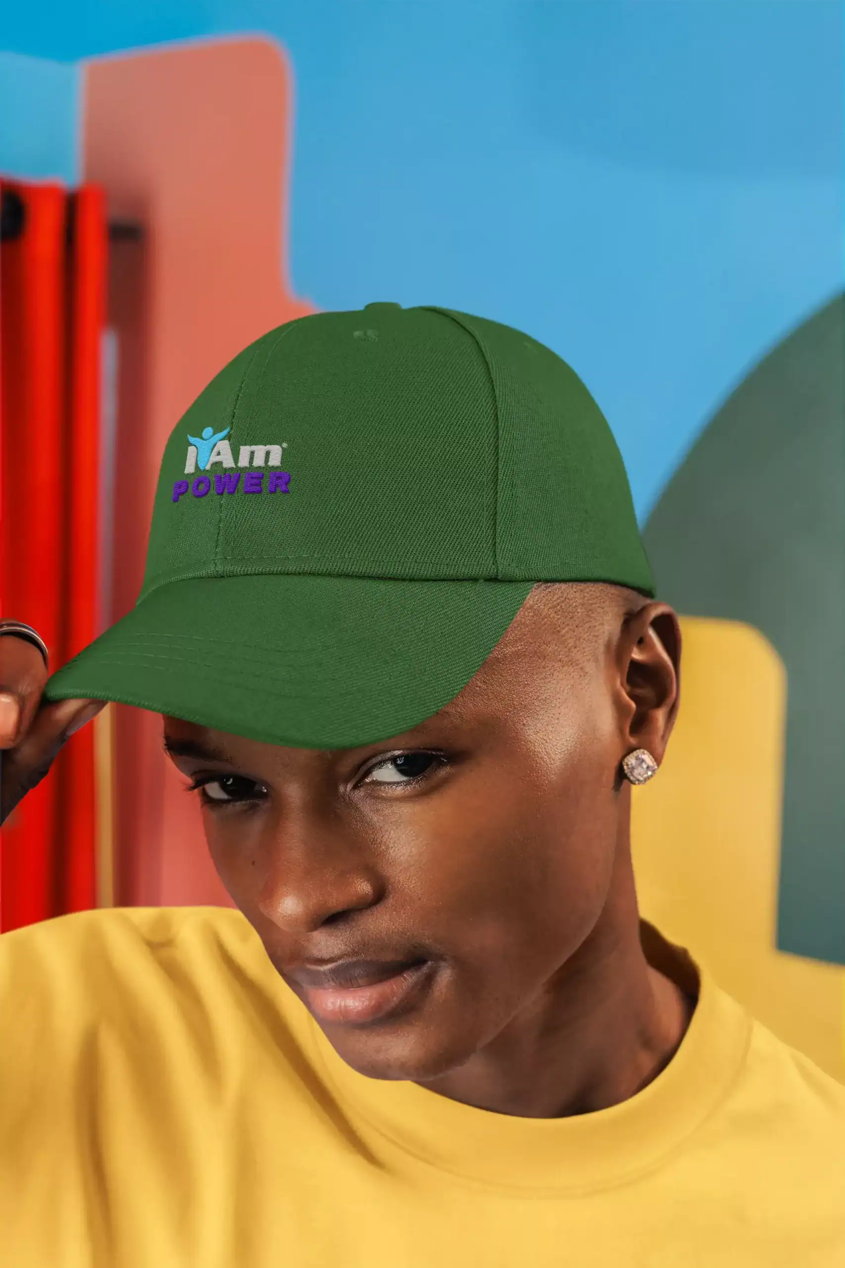 20260616093419-1f169668-c880-6c8a-a7b0-362ee6a79e6b.webp Green baseball cap with 'I Am Power' logo worn by a young man.
